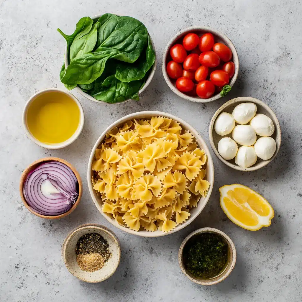 Ingrédients pour une salade de pâtes farfalle : pâtes, tomates, mozzarella et basilic
